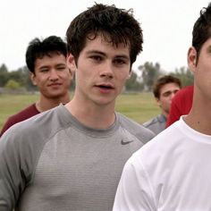 a group of young men standing next to each other in front of a soccer field