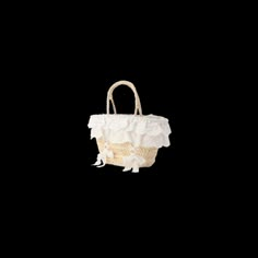 a handbag with white flowers on it is shown against a black background in the dark