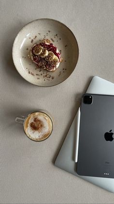 a plate with food on it next to a cup of cappuccino and an ipad