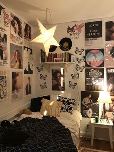 a bed room with a neatly made bed and lots of posters on the wall