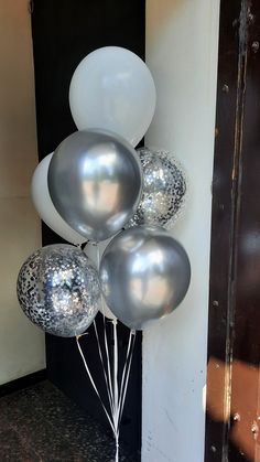 some silver and white balloons are on the ground