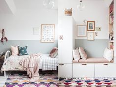 a bedroom with white walls and colorful rugs