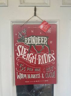 a red sign hanging from the side of a door that says reindeer sleigh rides