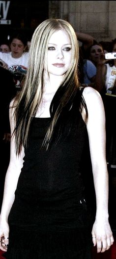 a black and white photo of a woman with long hair in a black dress posing for the camera