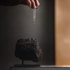 a person is holding an object in their hand while standing on top of a rock