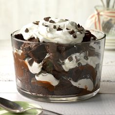 a glass dish filled with chocolate cake and whipped cream