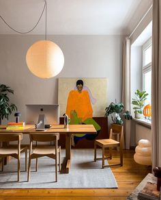 a man sitting at a table in front of a laptop computer on top of a rug