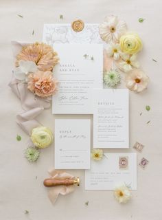 the wedding stationery is laid out with flowers