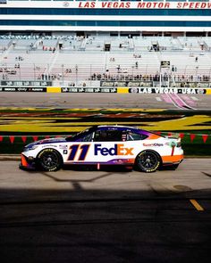 a white and orange car driving down a race track