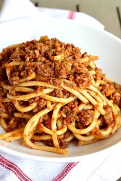 a white bowl filled with spaghetti on top of a table