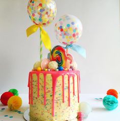 a colorful birthday cake with balloons and confetti