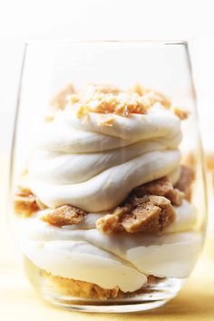 a dessert in a glass with icing and nuts on top