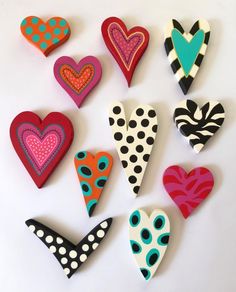 several heart shaped magnets are arranged on a white surface with polka dots and hearts