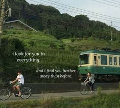 two people riding bikes next to a green and yellow train on the tracks with a quote written above it