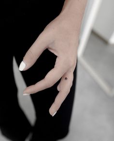 a woman's hand with a tiny star tattoo on her left thumb and finger