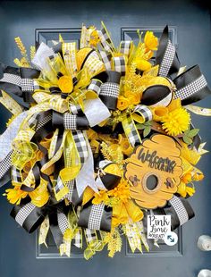 a yellow and black wreath with sunflowers on the front door for fall decor