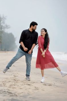 a man and woman dancing on the beach