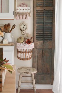 a kitchen with an old door and wooden shelves on the wall next to a stool