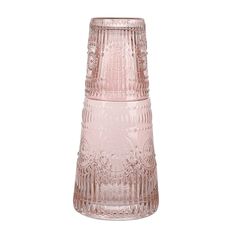 a pink glass vase sitting on top of a white table