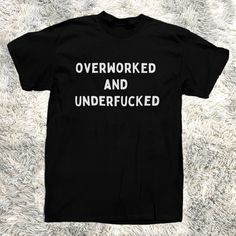 Introducing The T-Shirt That Speaks Your Truth Louder Than Your Boss Yells At You The "Overworked And Underfucked" Men's Tee! Crafted From 100% Pure Cotton, This Black Beauty Is Perfect For Those Who Need A Laugh As Much As They Need A Vacation. Wear It To The Office, The Bar, Or Your Next Therapy Session Wherever The Truth Needs To Be Told. Warning: This Shirt May Cause Spontaneous High-Fives And Knowing Nods From Fellow Sufferers. Funny Saying For Shirts, Sarcastic Shirts For Men, Black Relaxed Fit T-shirt With Funny Text, Funny Black Screen Printed Top, Funny Black Screen Print Top, Black Relaxed Fit Funny T-shirt, Black T-shirt With Funny Text In Relaxed Fit, Funny Black Shirt For Streetwear, Black Tops With Funny Text For Streetwear