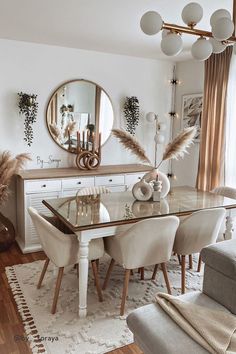 a dining room table with chairs and a mirror on the wall above it, in front of a couch