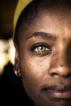 a close up of a person with freckles on their face and eyeliners