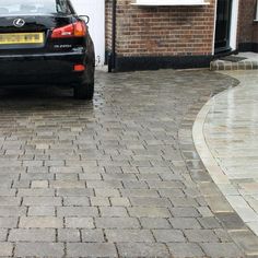 a black car parked in front of a brick building