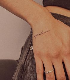 a woman's hand with a small tattoo on it