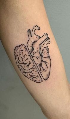 a black and white image of a human heart and brain tattoo on the right arm