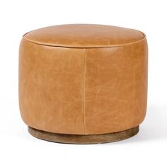 a tan leather ottoman sitting on top of a wooden table