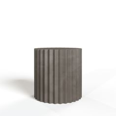 a grey vase sitting on top of a white table