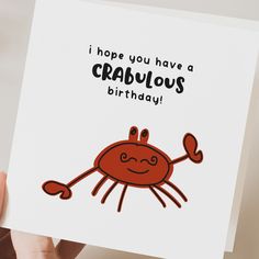 someone holding up a card with a crab on it