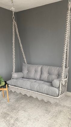 a white couch sitting in a living room next to a table with a potted plant on it