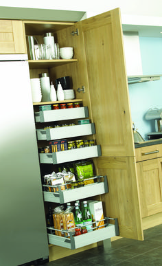 an open cabinet in the middle of a kitchen