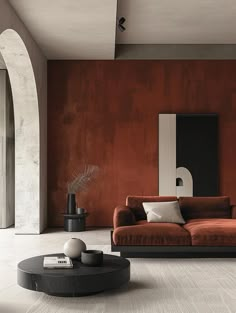 a living room with an orange couch and black coffee table in front of a red wall