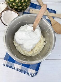 a bowl filled with whipped cream next to a pineapple