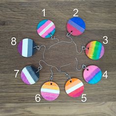 multicolored wooden earrings are arranged in a circle on top of a wood table