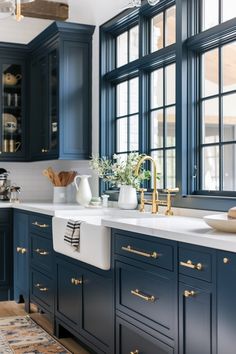 a kitchen with blue cabinets and white counter tops