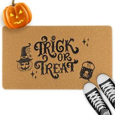 a door mat that says trick or treat with pumpkins and jack - o'- lanterns