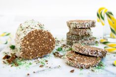 three pieces of food sitting on top of a table next to a glass filled with candy