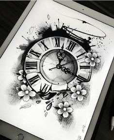 a drawing book with an image of a clock and flowers on the cover, next to a pen