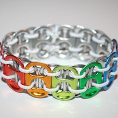 a multicolored bracelet is shown on a white surface with an oval link in the middle