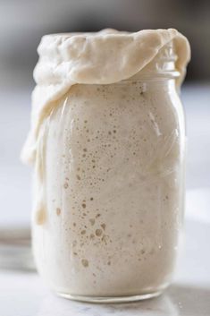 a glass jar filled with liquid sitting on top of a table