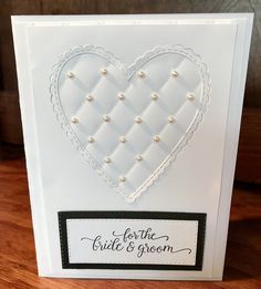 a white card with a heart and pearls on the front that says fortie bride's groom