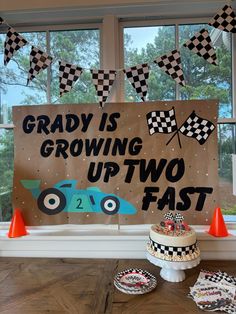 a birthday party with race car decorations and a sign that says grady is growing up two fast