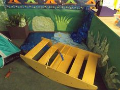 a wooden bed frame sitting on top of a floor next to a potted plant