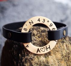 a close up of a bracelet on a rock with the word hoa engraved in it