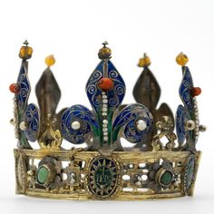 a gold and blue crown on a white surface with an orange bead around the crown