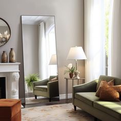 a living room filled with furniture and a large mirror on the wall over a fireplace