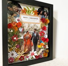 a frame with flowers and pictures on it